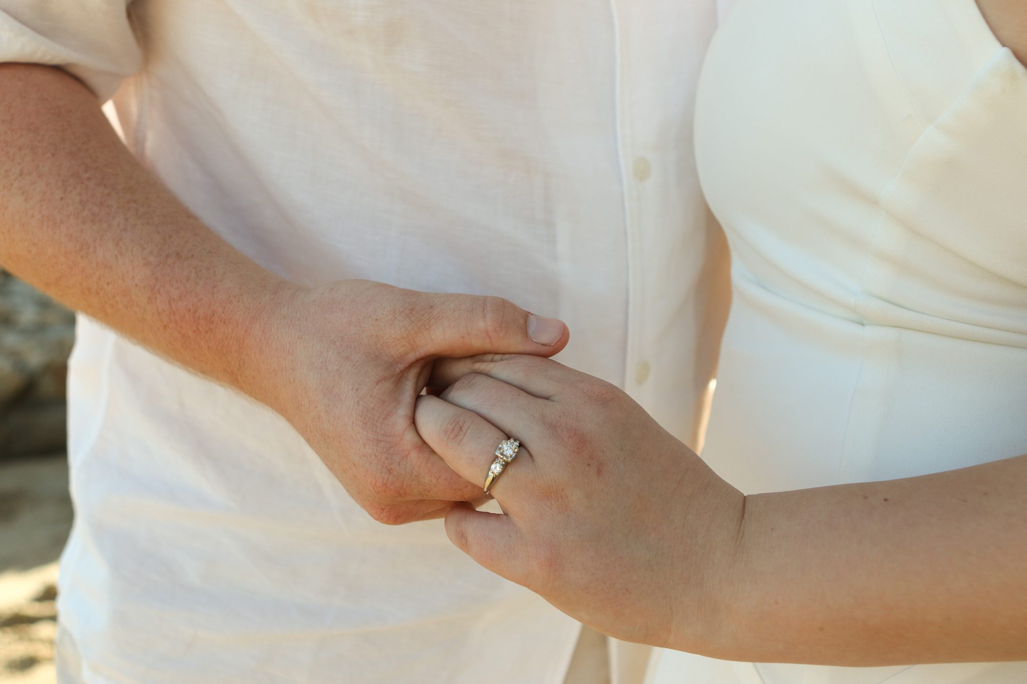 Close-up of the couple holding hands, engagement ring visible